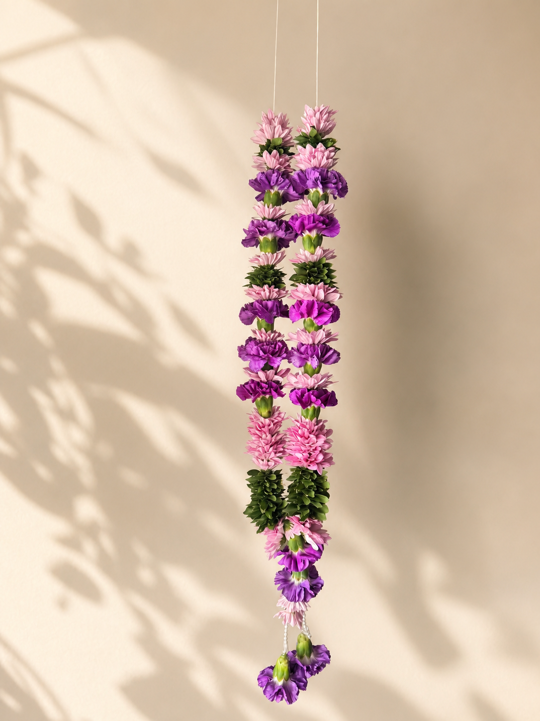 Purple and pink welcome garland alternate product view on ivory leaf-shadow backdrop
