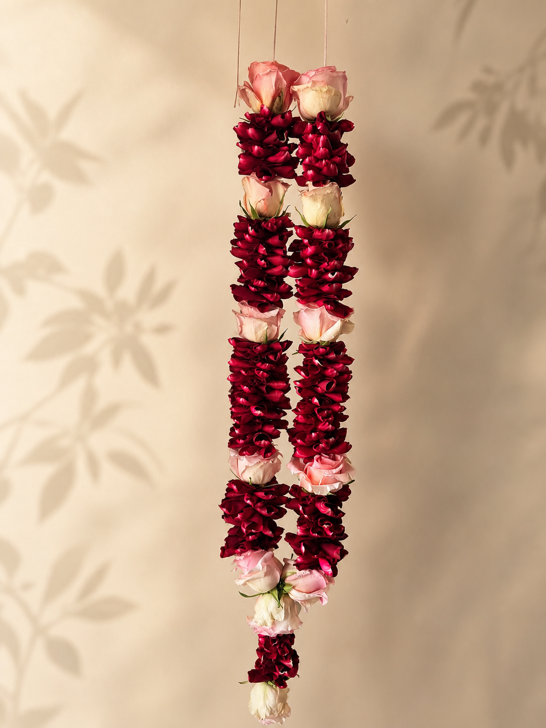 Ruby and pink rose petal mala alternate product view on ivory leaf-shadow backdrop