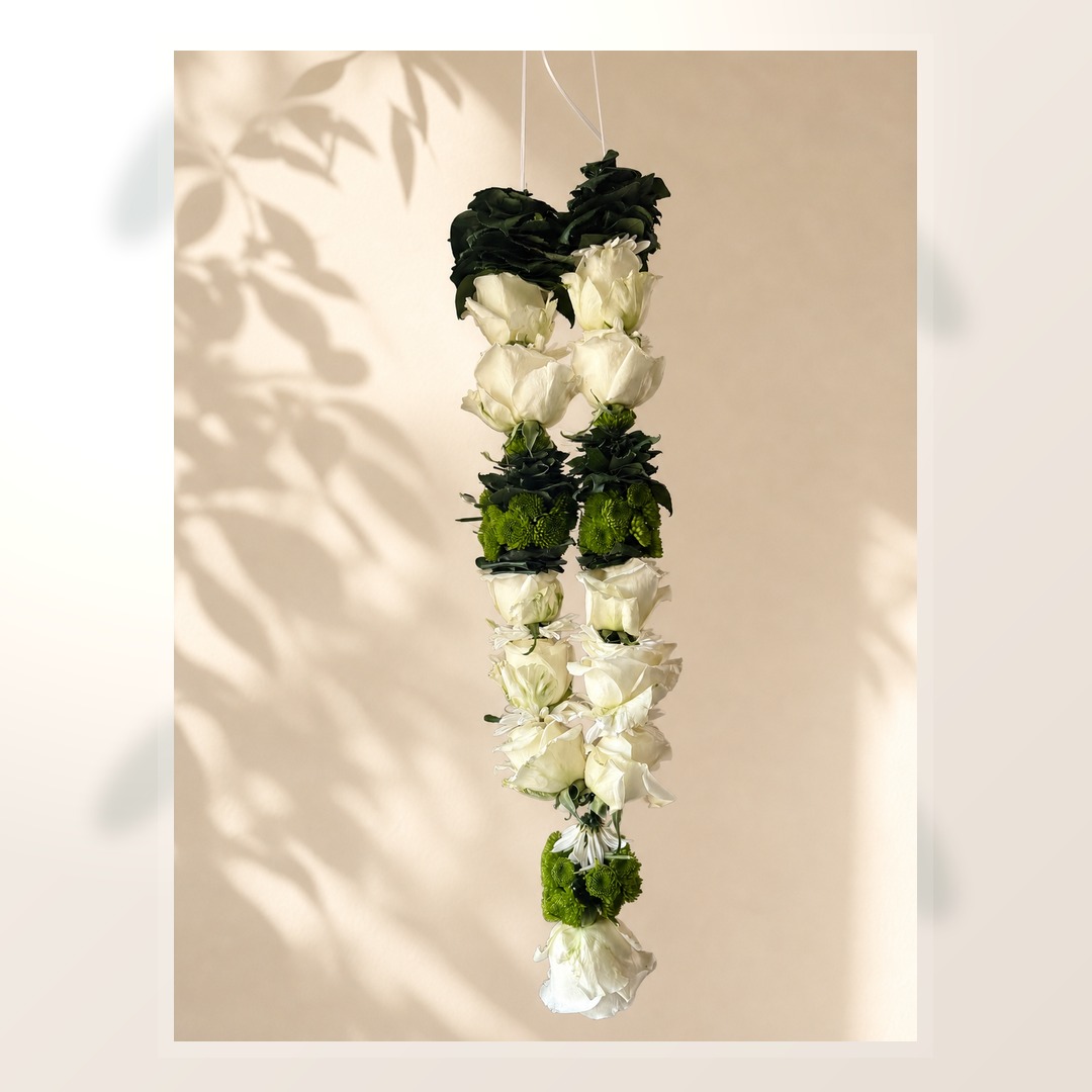 Ivory rose and green mum hanging garland on warm ivory leaf-shadow backdrop