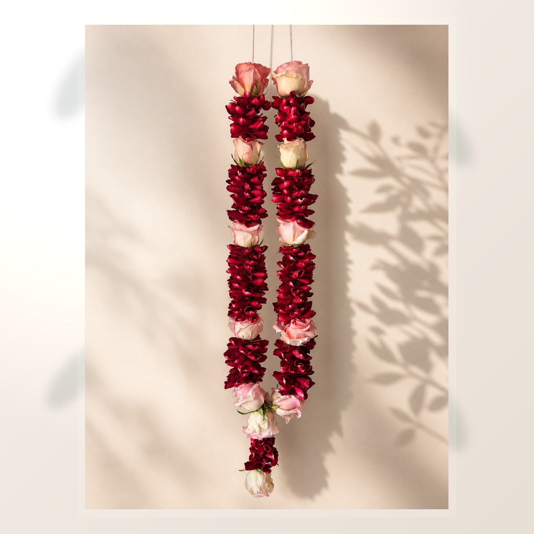 Ruby petal and blush rose hanging mala on ivory leaf-shadow backdrop
