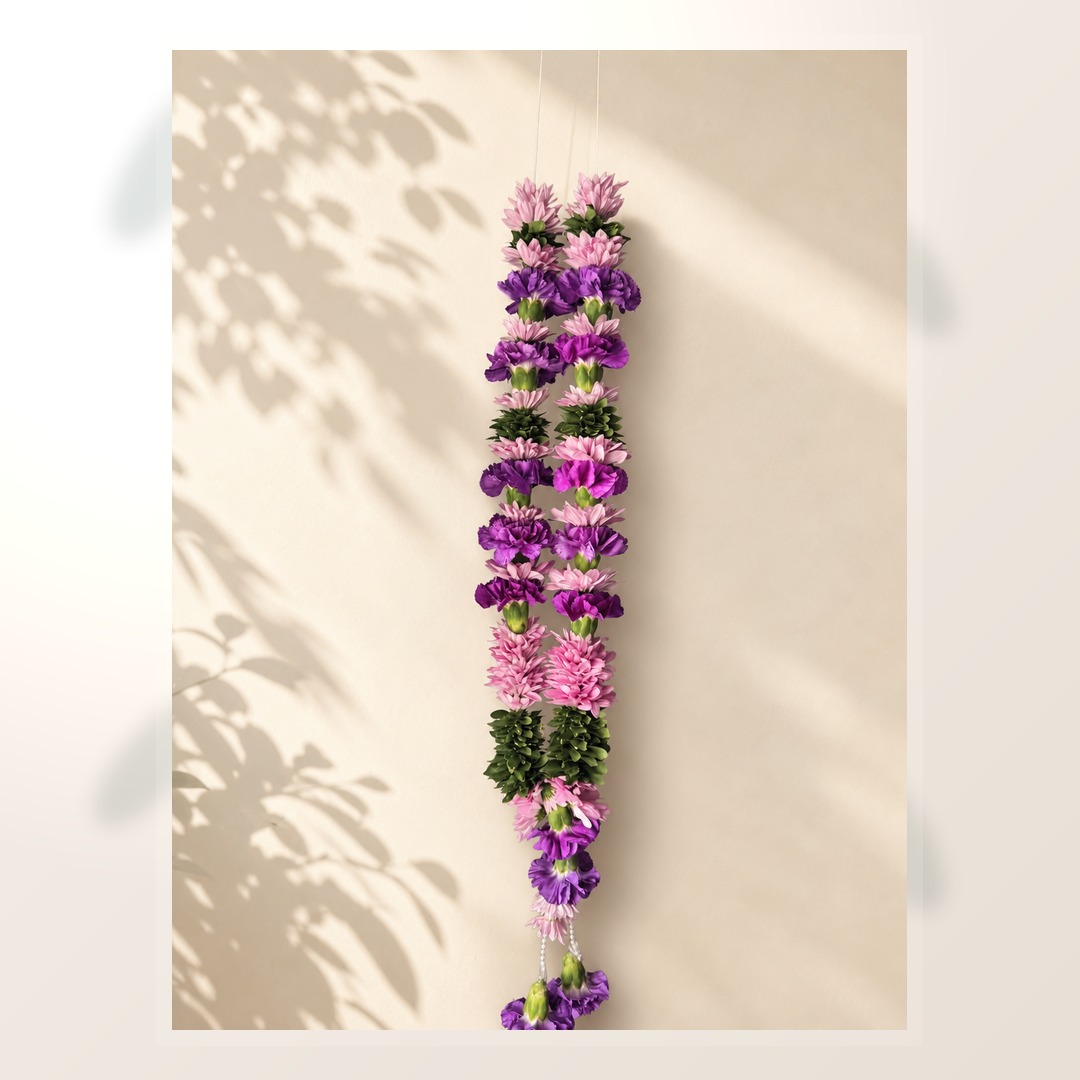 Purple and pink floral welcome garland on ivory leaf-shadow backdrop