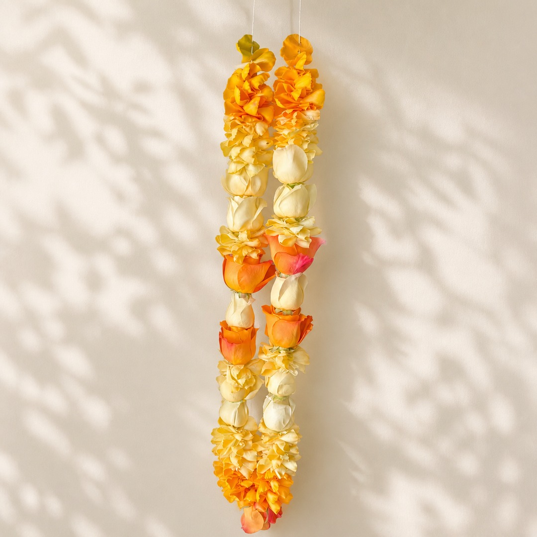 Sunshine orange, yellow, and cream rose petal garland on a warm leaf shadow background