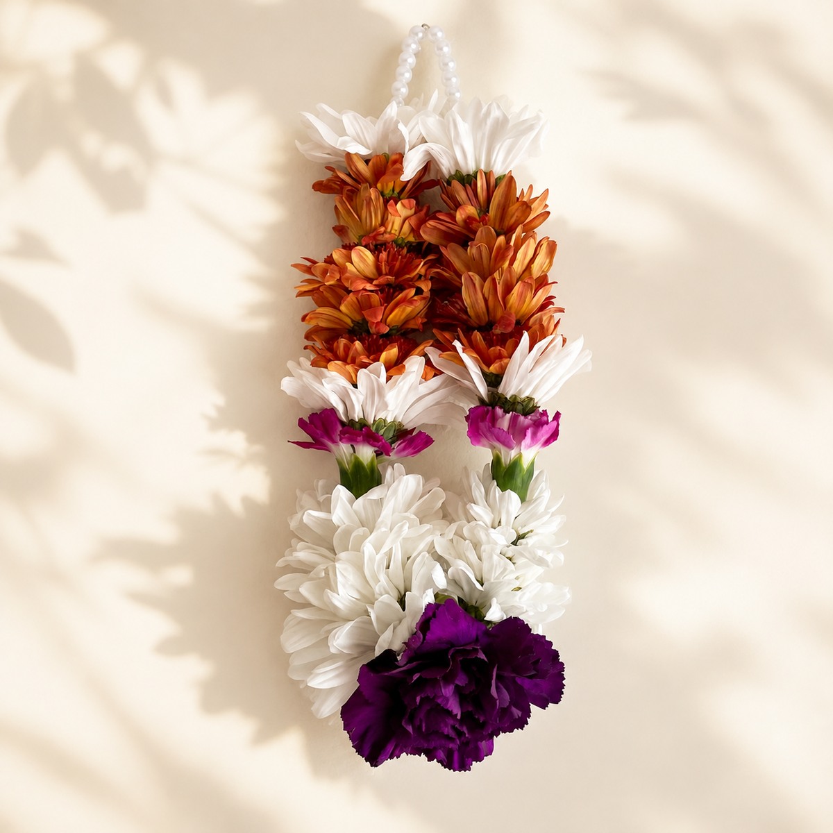 Autumn daisy orchid hanging garland on warm ivory leaf-shadow backdrop