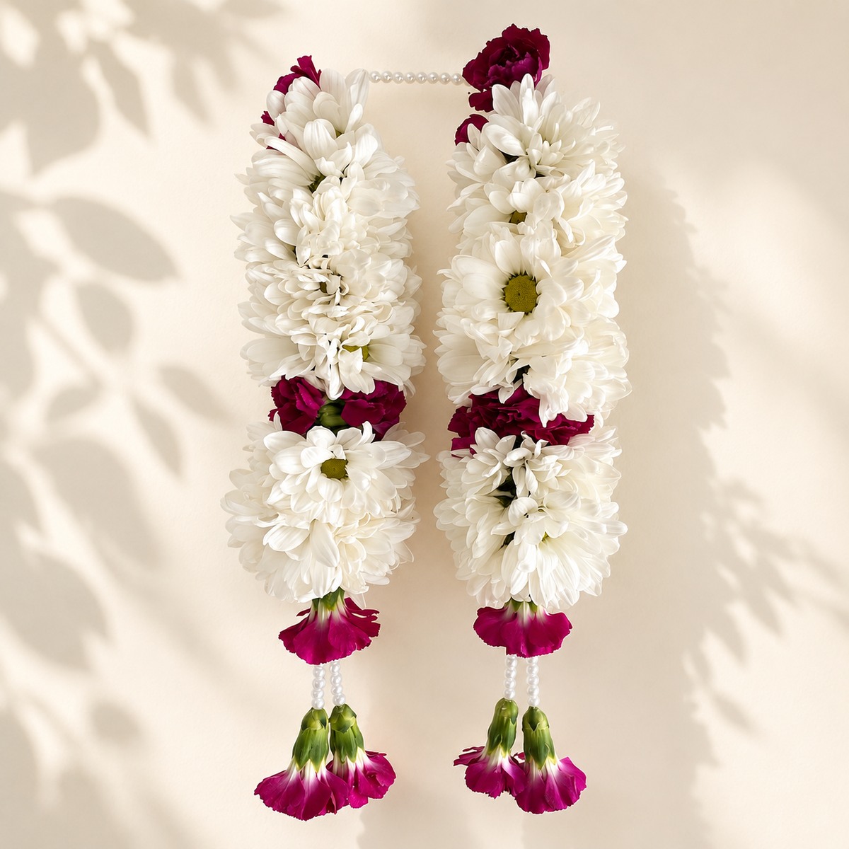 White and purple daisy hanging garland pair on warm ivory leaf-shadow backdrop
